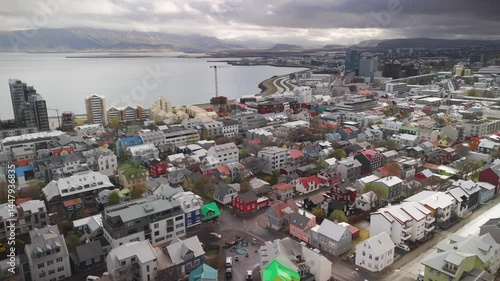aerial view of Reykjavik in Iceland during a cloudy day showing the city skyline, the sea, mountains, and building