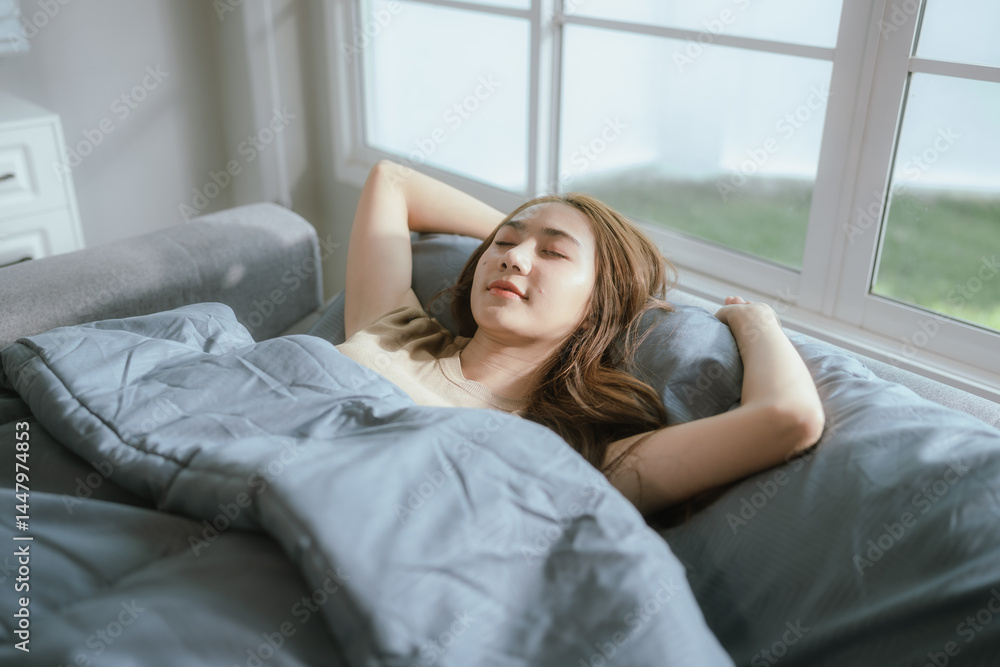Attractive young woman stretching happily on a cozy bed in a sunlit bedroom, enjoying a peaceful and relaxing morning moment. Attractive young woman stretching happily on a cozy bed in a sunlit bedroom, enjoying a peaceful and relaxing morning moment.
