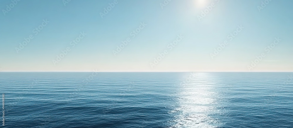 Obraz premium Calm sea under clear blue sky with sunlight glimmering on water surface.