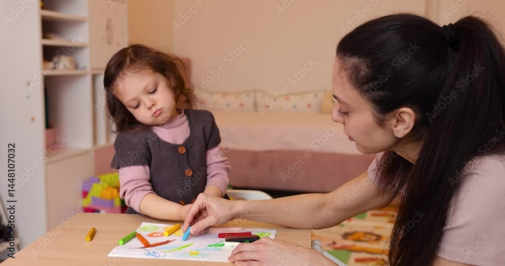 cute little child girl with her mother drawing picture using a pencil crayon on white paper at home, creative activity cute little child girl with her mother drawing picture using a pencil crayon on white paper at home, creative activity