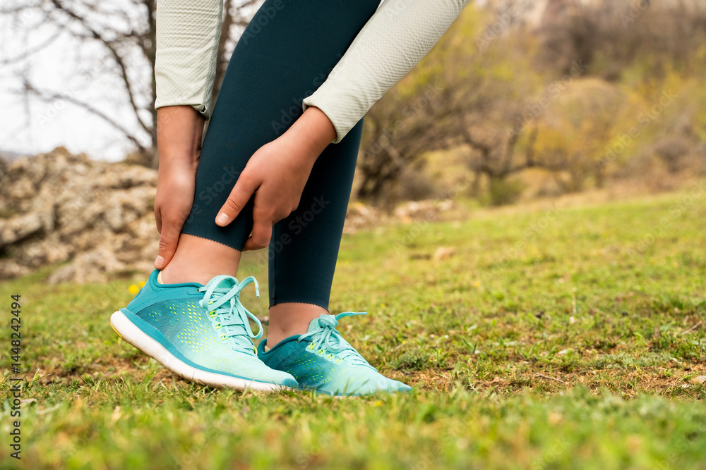 Φωτογραφία Woman holding ankle injury, feeling pain in her foot in nature park, sports trau