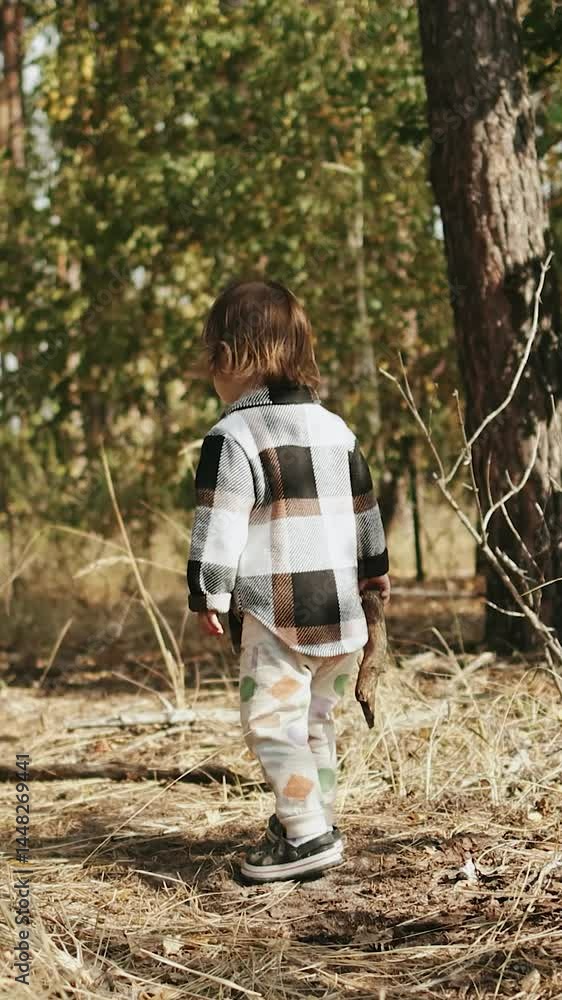 Vertical screen: A young child walking through a serene and tranquil forest, surrounded by lush trees and vibrant greenery. Vertical screen: A young child walking through a serene and tranquil forest, surrounded by lush trees and vibrant greenery.
