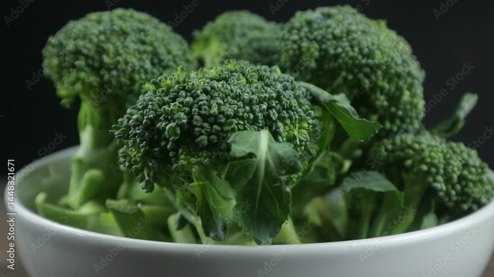 Fresh green broccoli in bowl rotating against black background Fresh green broccoli in bowl rotating against black background