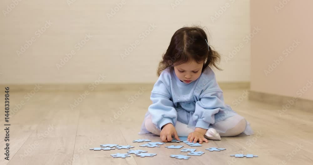 toddler child girl collects puzzles on floor at home, development of fine motor skills and logic toddler child girl collects puzzles on floor at home, development of fine motor skills and logic