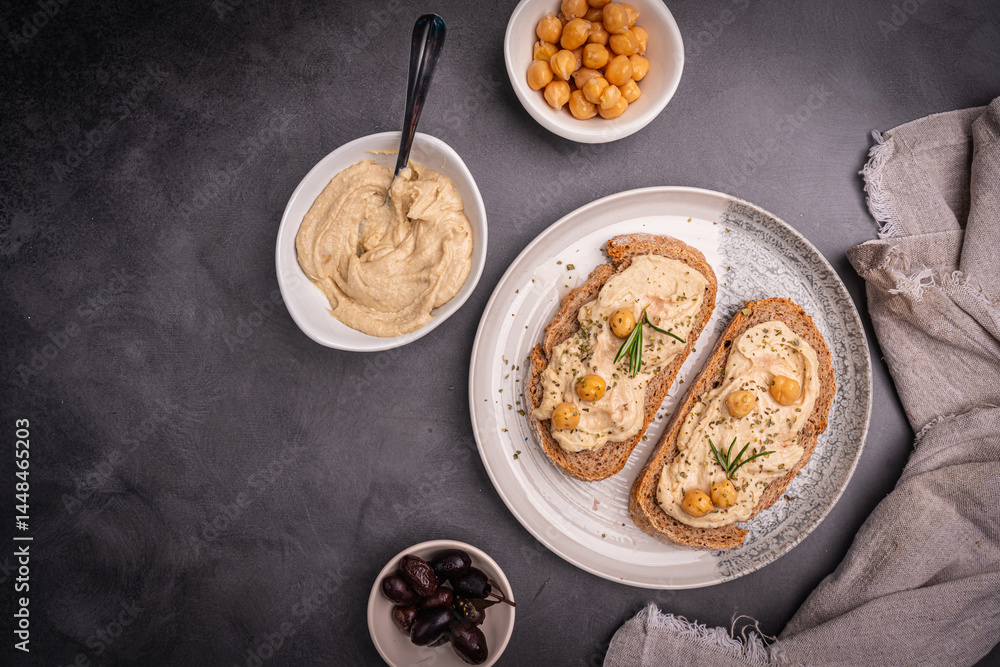Delicious sandwiches with hummus and ingredients on a dark background, top view, flat lay. High quality photo