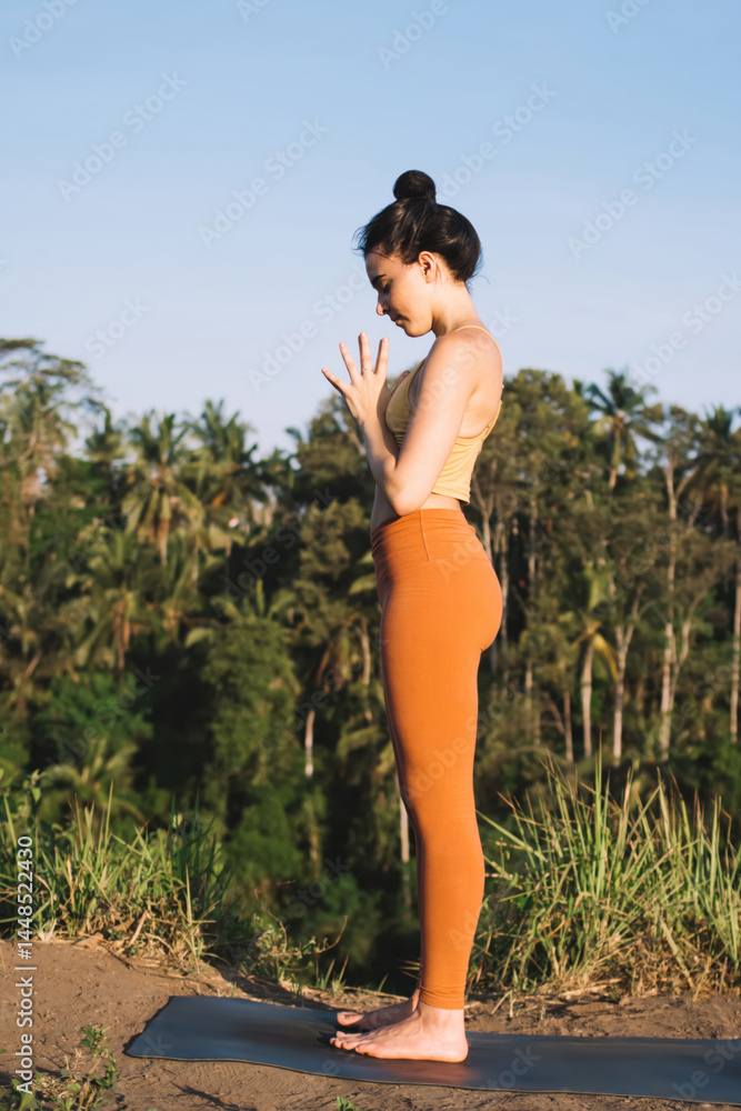 Young woman practicing yoga in open air
