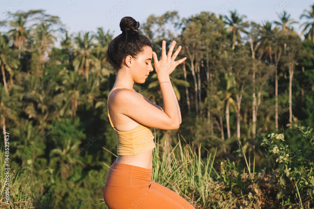 Pensive concentrated caucasian woman meditating and recreating on free time sitting on field enjoying nature, teen female in active wear concentrated on mental and physical harmony in asana