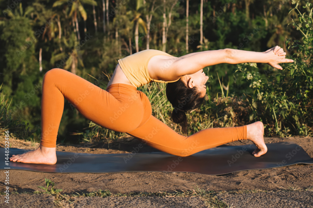 Flexible fit lady doing yoga lunges in tropical nature