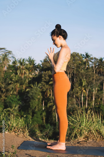 Young woman practicing yoga in open air