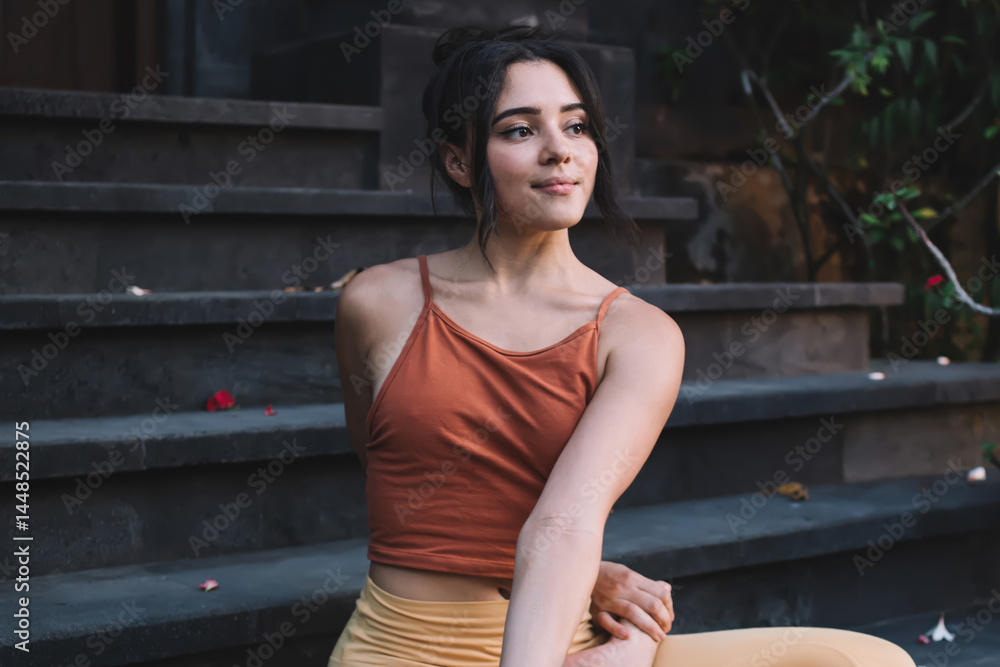Young woman enjoying harmony doing Lotus Pose Twist on steps