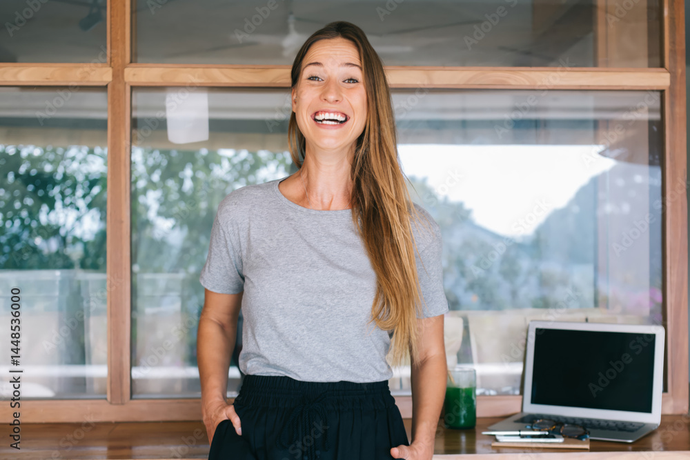 Smiling woman standing near reception in modern office