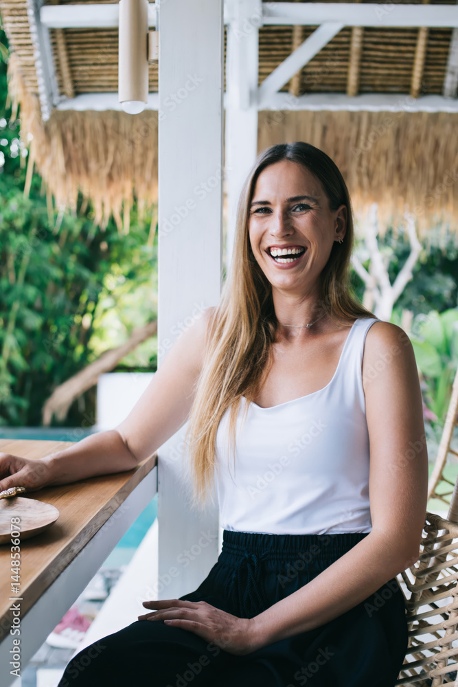 Cheerful young woman laughing while eating exotic food
