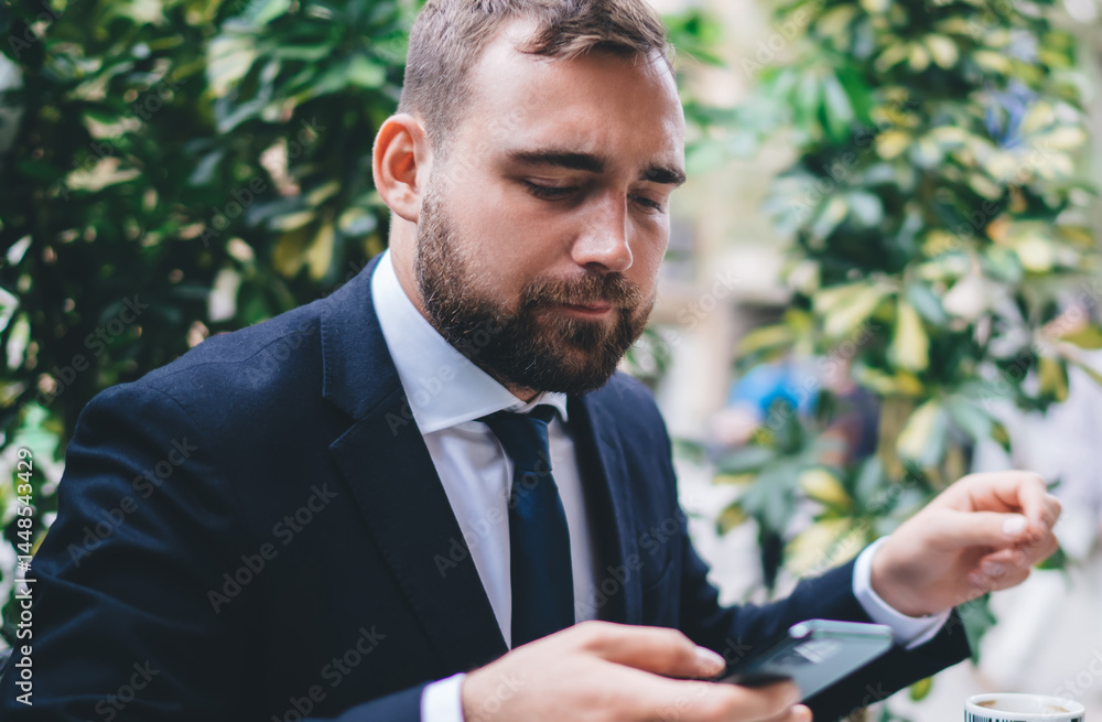 Businessman browsing smartphone in street cafe