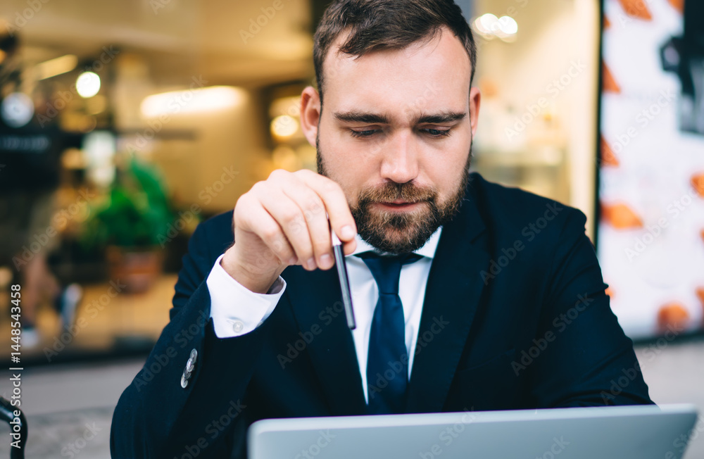 Serious businessman using laptop in cafe