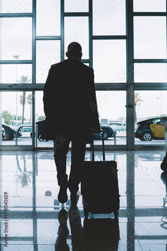 Obraz na płótnie Anonymous man with luggage walking in airport w salonie