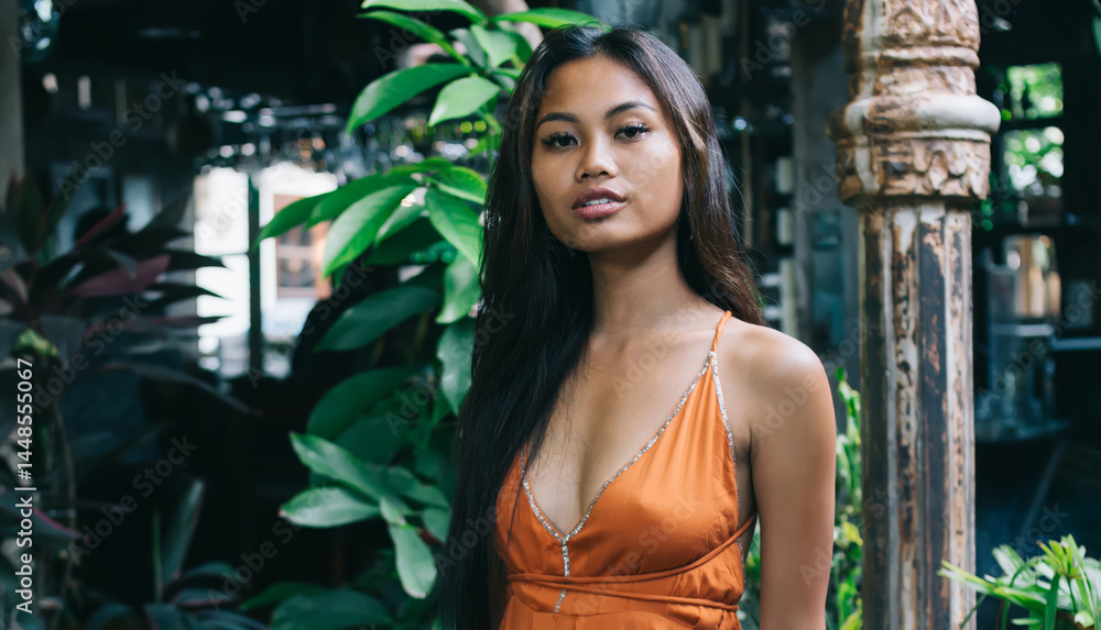 Stylish young ethnic lady among tropical plants