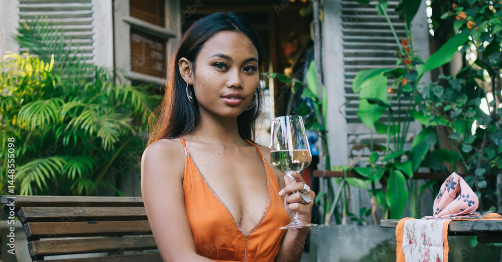 Stylish young ethnic woman drinking drinking wine on terrace of