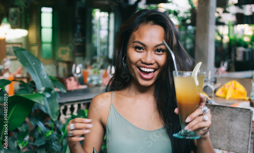 Obraz na płótnie Happy young ethnic lady enjoying cold natural juice and exotic f w salonie