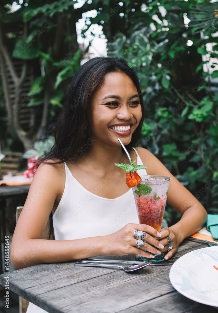 Cheerful woman with cocktail in cafe