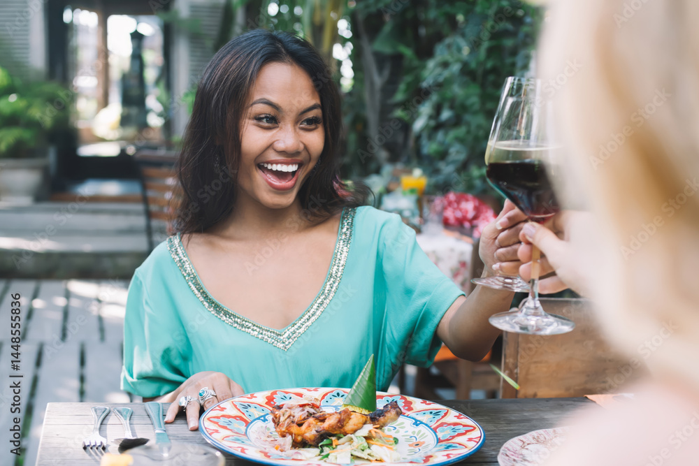 Happy women drinking wine in outdoor cafe