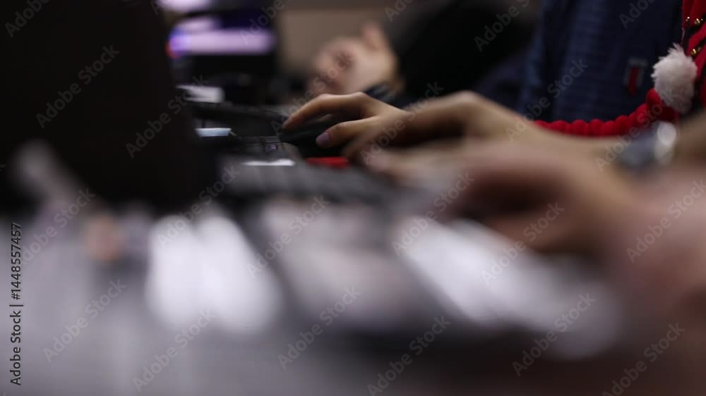 Hands typing on a gaming keyboard with neon lights on a dark background, with the red light shining on hands. The light is colorful and vibrant. Hands typing on a gaming keyboard with neon lights on a dark background, with the red light shining on hands. The light is colorful and vibrant.