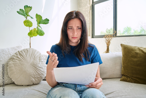 Webcam view young serious woman with business papers having video