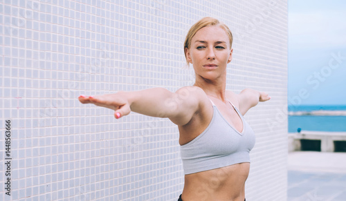 Obraz na płótnie Caucasian fitness girl doing stretching exercise during sport training outdoors to improve health and physical form, active young woman warm up for better flexibility during pilates poses at urbanity w salonie