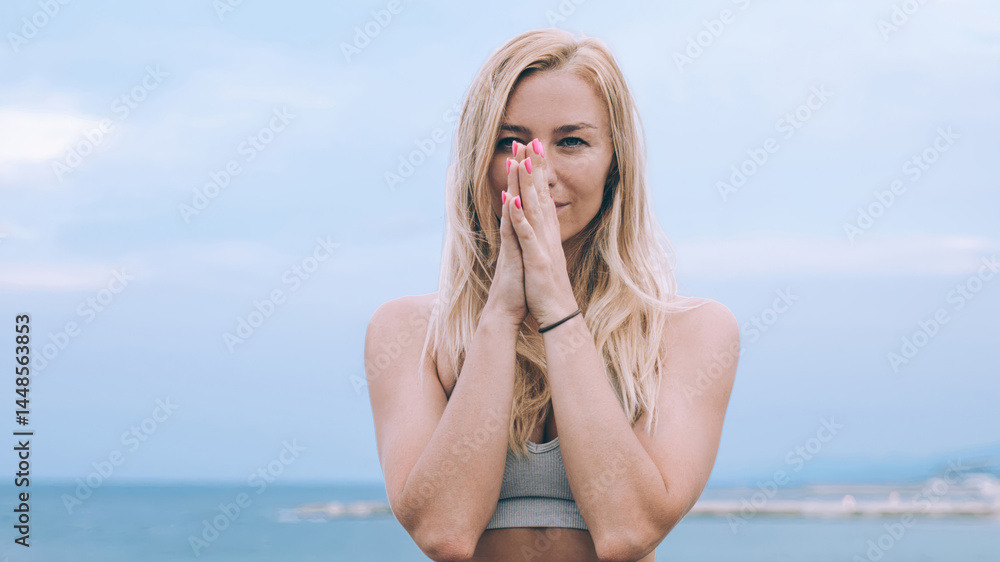 Slim woman sitting in lotus pose near seafront