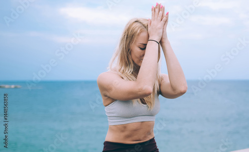 Obraz na płótnie Caucasian woman calms brain minds with lotus yoga pose enjoying morning training near coastline, good looking female increases awareness and attentiveness with padmasana meditation exercise w salonie