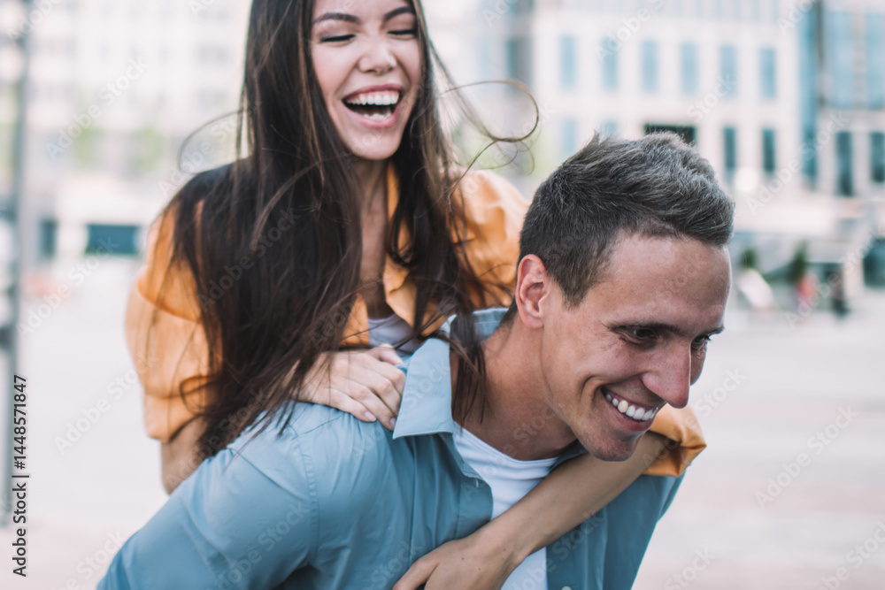 Happy man giving piggy back to girlfriend