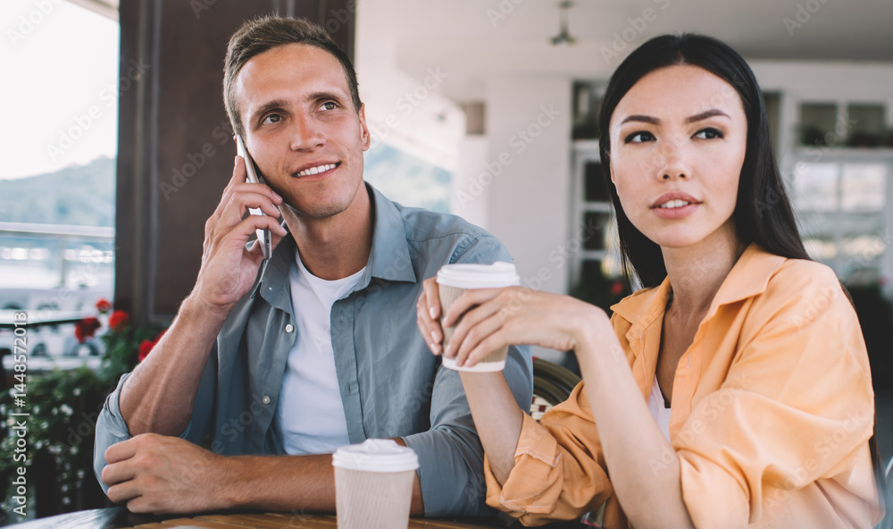 Modern colleagues drinking coffee and making phone call