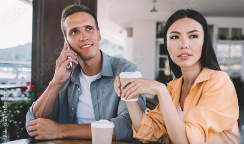 Modern colleagues drinking coffee and making phone call