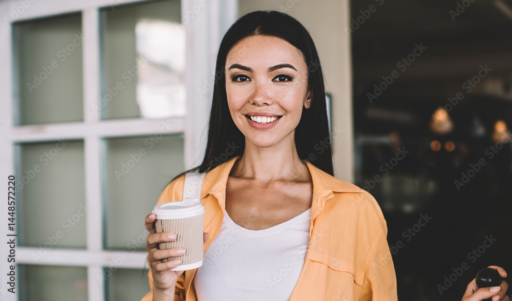 Cheerful ethnic woman standing with cup of coffee