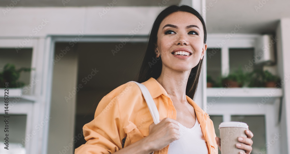 Smiling ethnic woman having coffee break in city