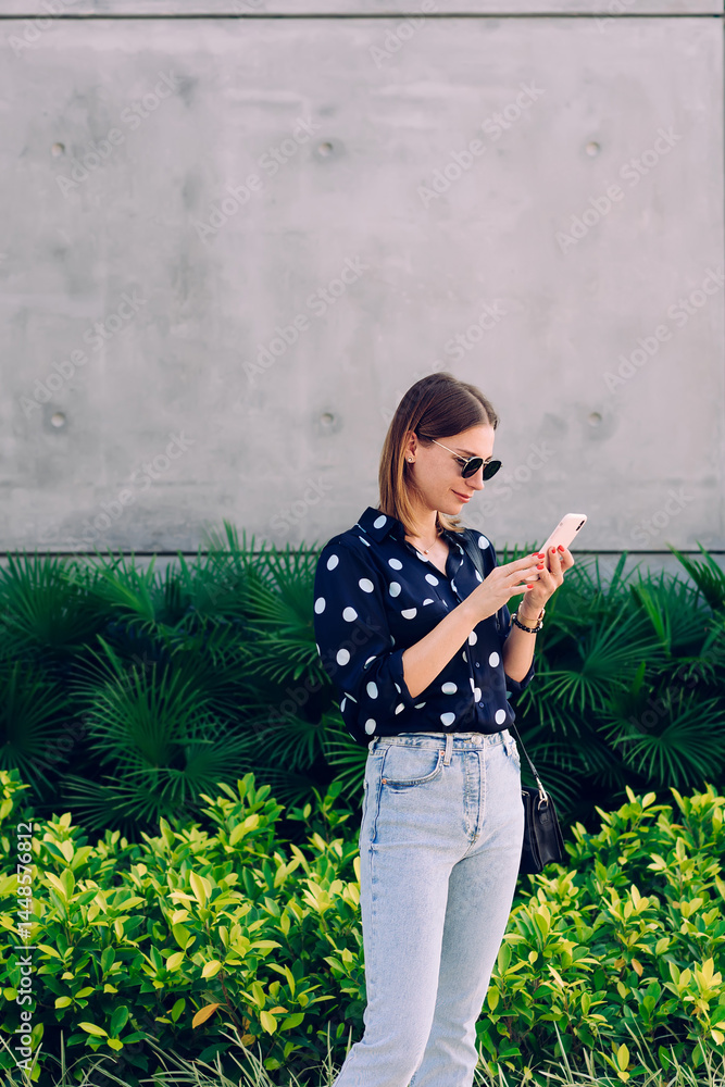 Attractive young woman surfing internet via cellphone