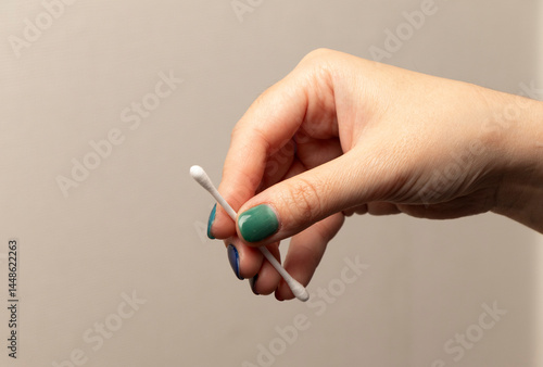 Foto una mano de mujer con las uñas pintadas tomando un hisopo, bastoncillo o cotonet