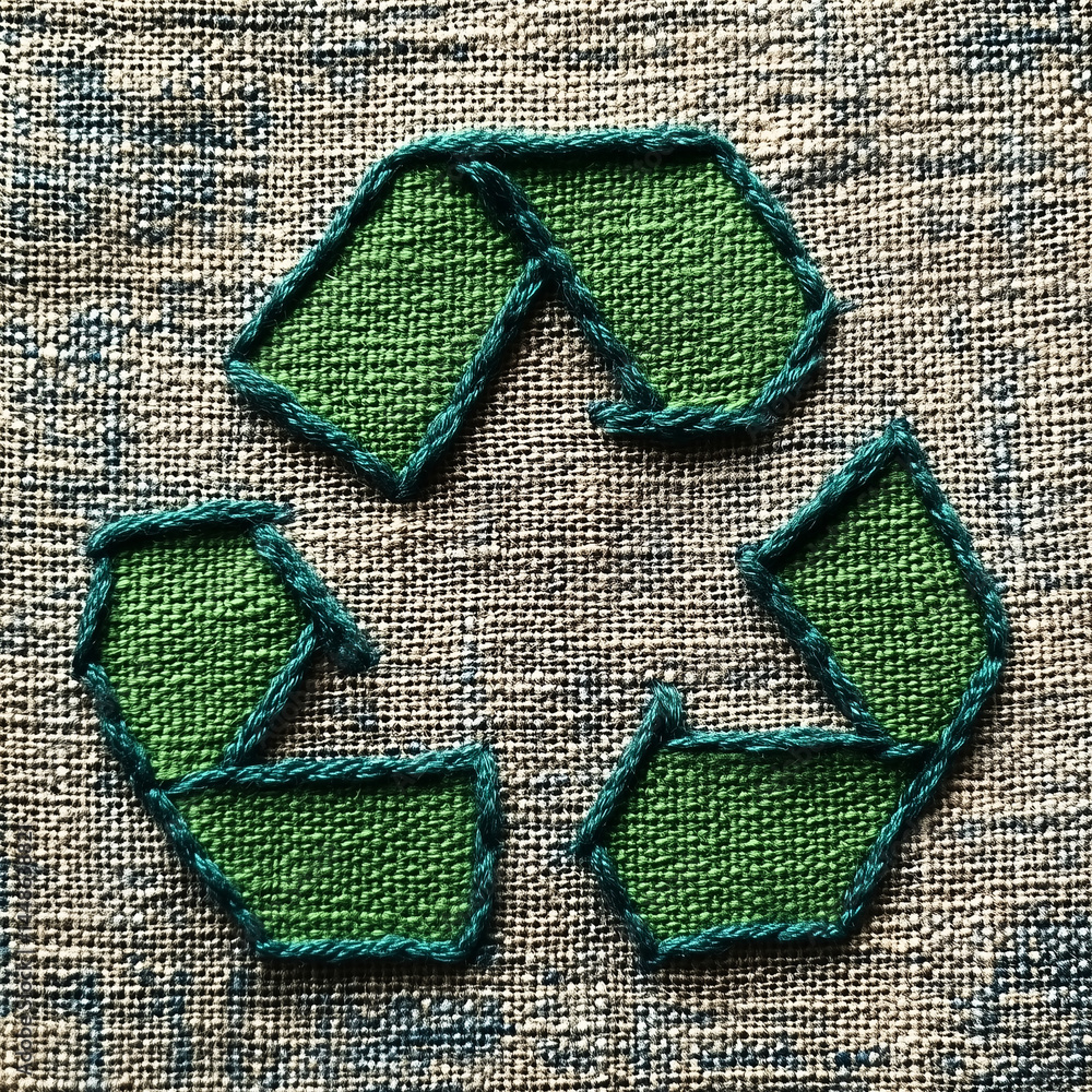Símbolo de reciclagem verde com costura detalhada e textura de linha visível. Ícone ecológico sobre fundo claro, representando conservação ambiental e design sustentável artesanal