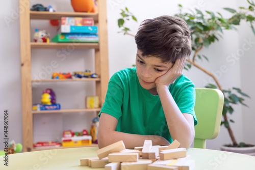 Fotografie Child Showing Frustration During Learning Activity with Wooden Blocks