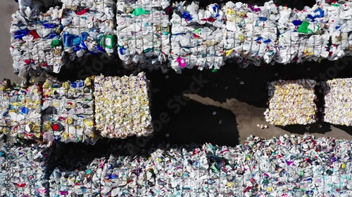 Aerial view of sorted and compressed plastic waste bales at an outdoor recycling plant, illustrating large-scale waste management operations.
