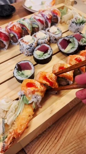 POV shot: person using chopsticks for fresh sushi dinner, dinner scene in warm setting, dinner offers comfort and simplicity, dinner tells relaxed urban story. Close view of assorted sushi meal