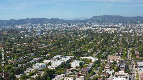 Aerial pullback shot of Los Angeles buildings, Hollywood sign, homes and hills