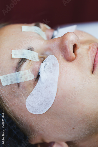 Obraz na płótnie Eyelash gluing method. Close-up of a woman's face during the procedure of Botox lamination of eyelashes. Eyelash care: lifting and curling, lamination and eyelash extensions. w salonie