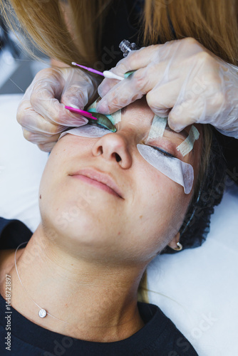 Obraz na płótnie Eyelash gluing method. Close-up of a woman's face during the procedure of Botox lamination of eyelashes. Eyelash care: lifting and curling, lamination and eyelash extensions. w salonie