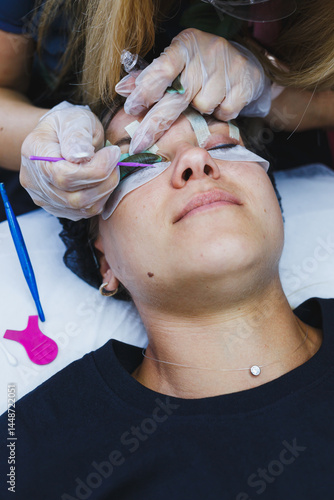 Obraz na płótnie Eyelash gluing method. Close-up of a woman's face during the procedure of Botox lamination of eyelashes. Eyelash care: lifting and curling, lamination and eyelash extensions. w salonie