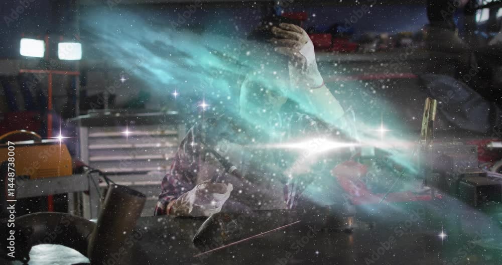 woman using welding torch in metal workshop, producing sparks with turquoise nebula overlay woman using welding torch in metal workshop, producing sparks with turquoise nebula overlay