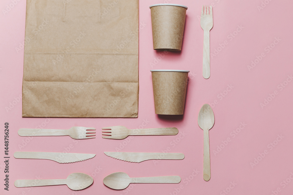 Flat lay composition with eco friendly paper disposable tableware on pink background.