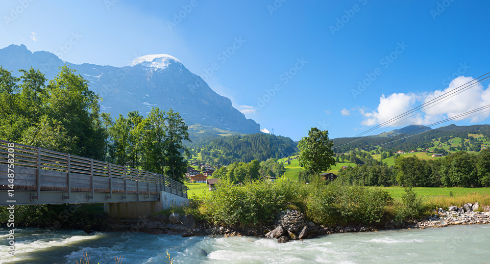 bridge over Schwarze Lutschine river, tourist resort Grindelwald, Eiger mountain switzerland