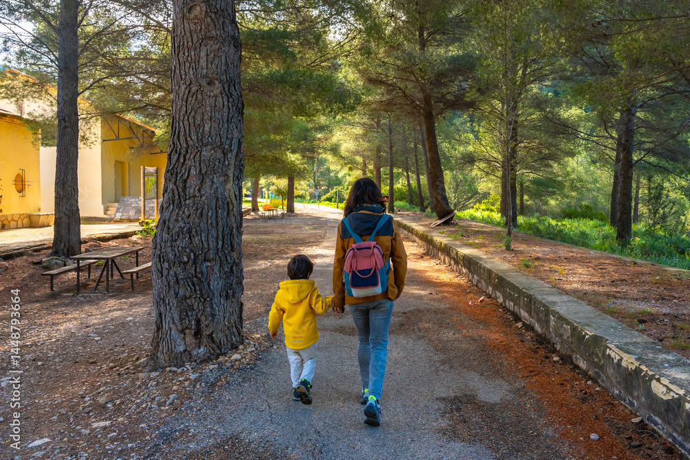 Mother and son walking in the sanctuary of fontcalda, gandesa, tarragona
