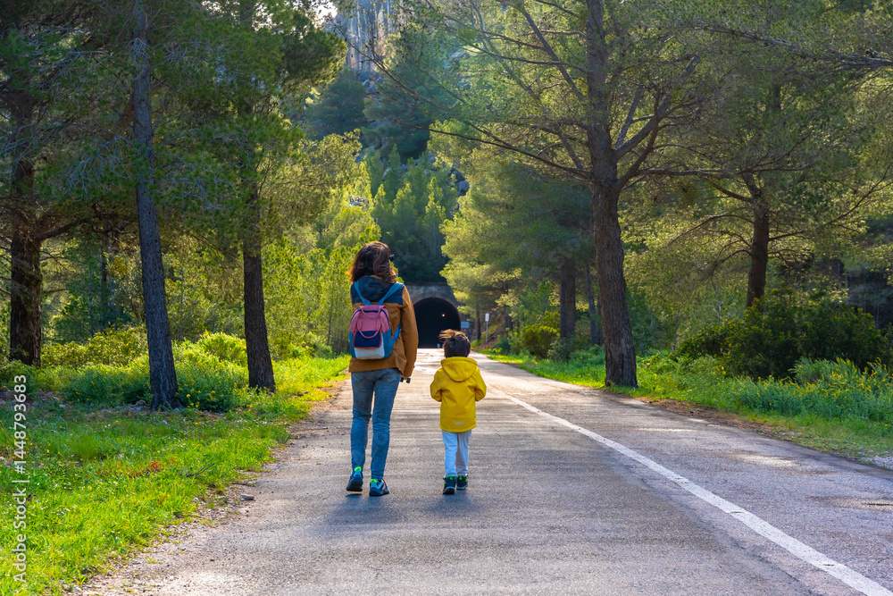 Mother and child walking on a scenic road in la fontcalda sanctuary, gandesa, tarragona