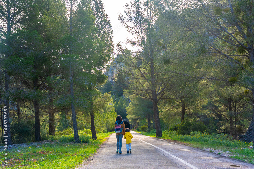 Mother and child walking on a scenic road in la fontcalda sanctuary